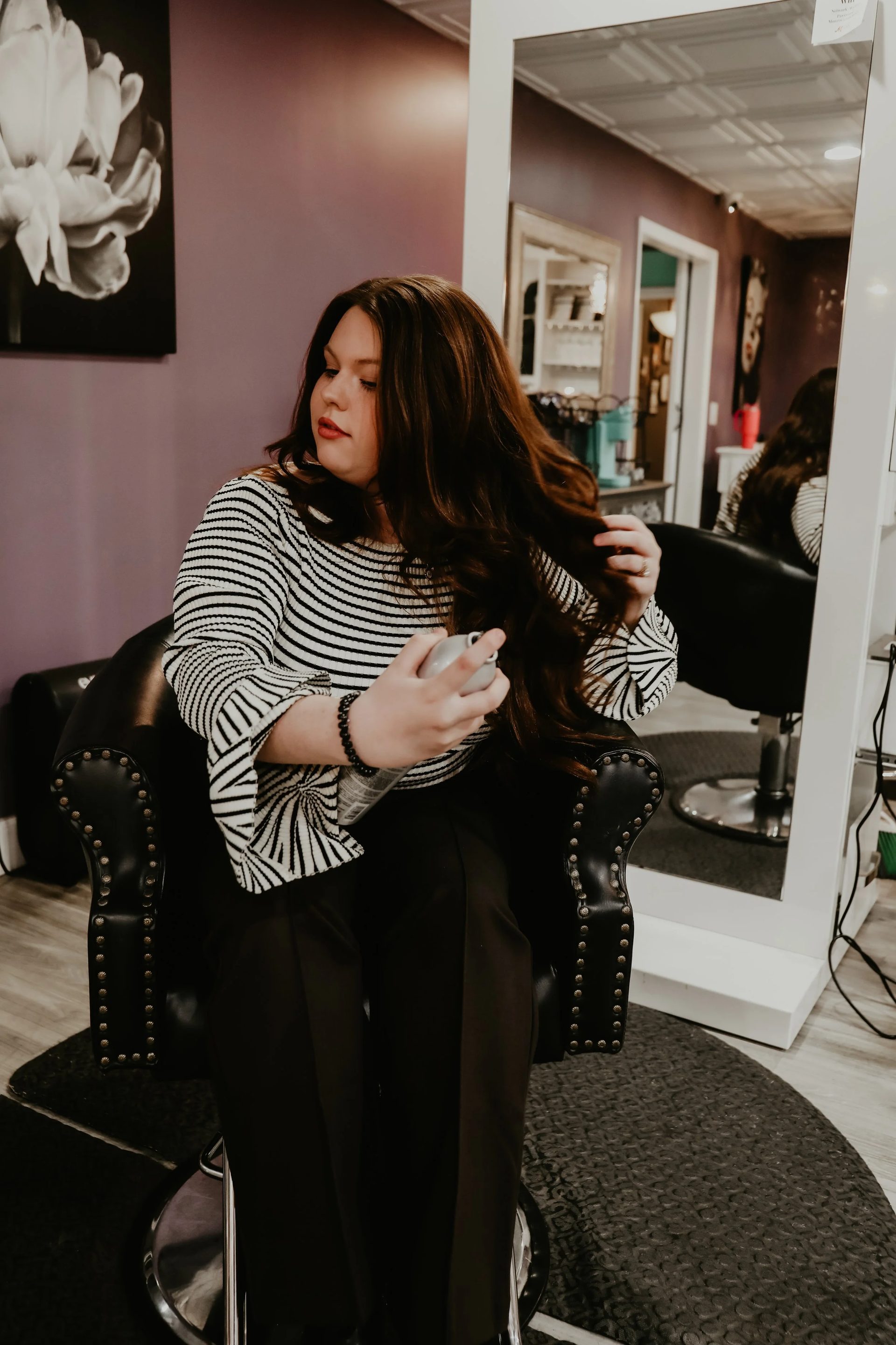 Stylist styling a client at a salon station inside All About Monroe in Demorest, Georgia