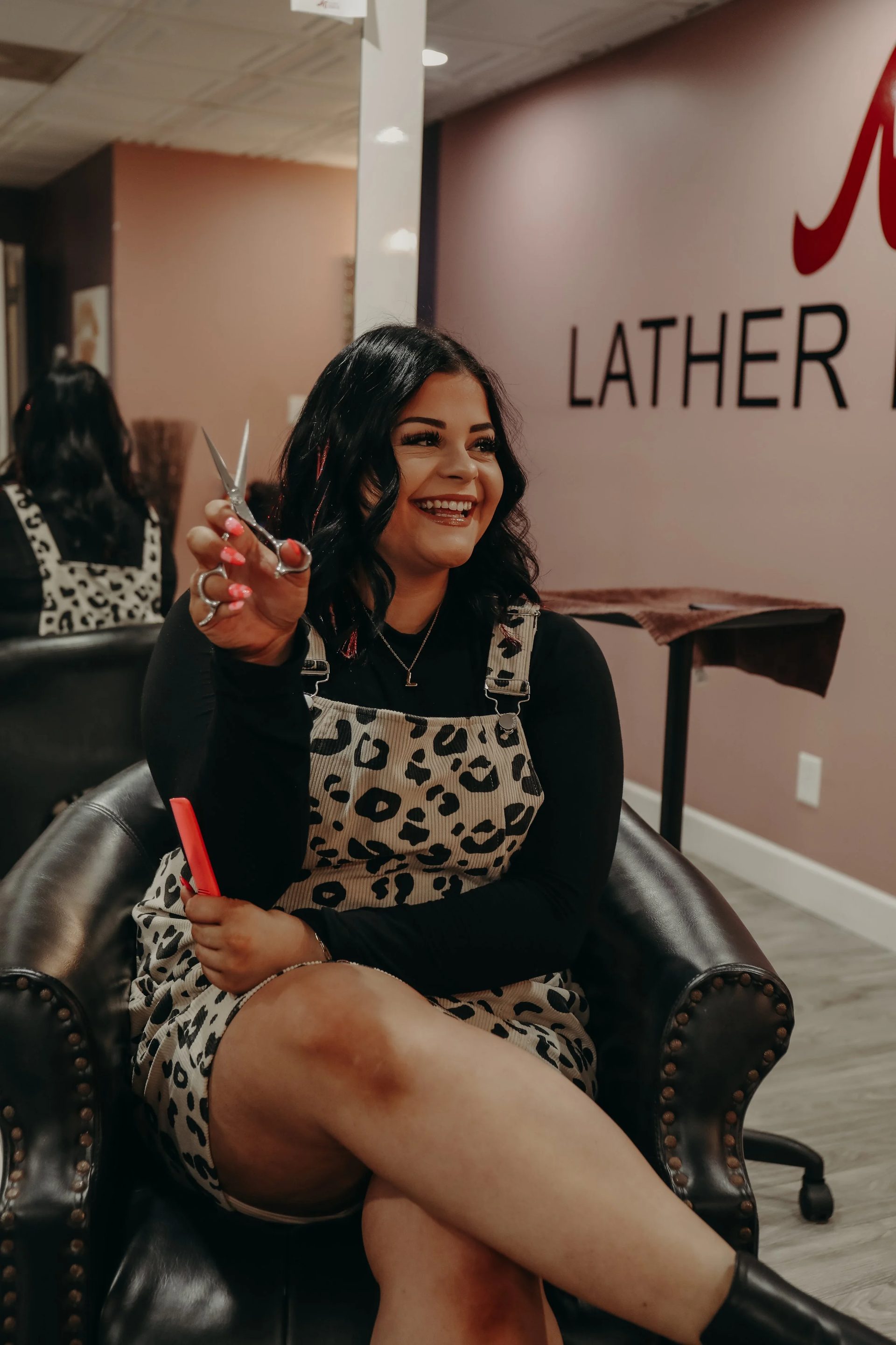 Master cosmetologist holding scissors in the salon at All About Monroe in Demorest, Georgia